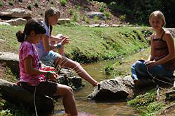 Girls weaving baskets by the creek