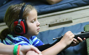 Kid at camp shooting a rifle