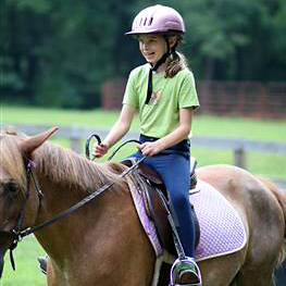 smiling camp girl horseback riding