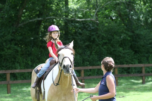 camp girl smiling on a horse