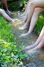 Camp girls soaking their feet in the creek