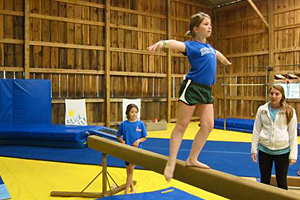 Camp child doing gymnastics on balance beam