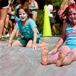 camp girls enjoying slip n slide