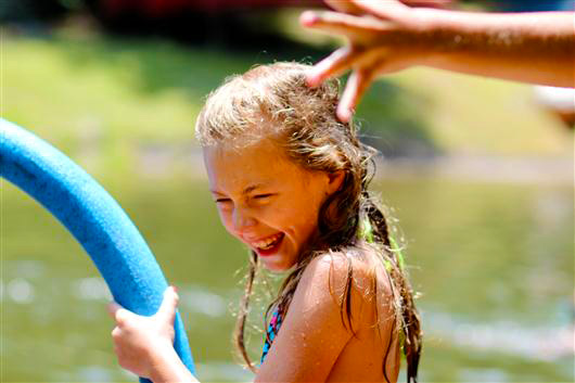 Camp girl smiles while swimming