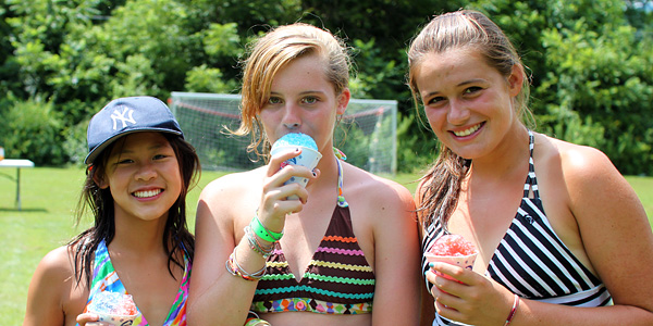 Camp girls eating snow cones in the sun