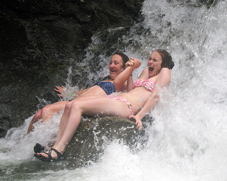 Teens sitting in waterfall