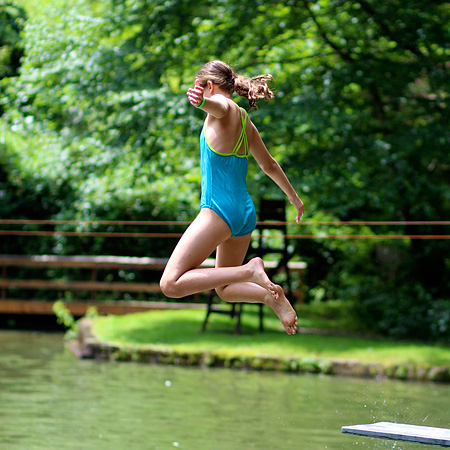 Camp girl jumping in the lake