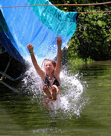 Girls splashing into lake from water slide