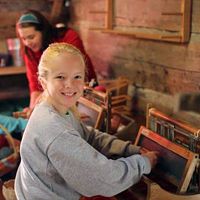 Camper learns to weave at summer camp