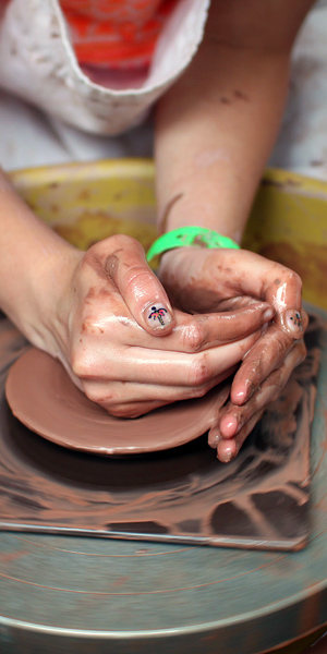Girls hands on pottery wheel