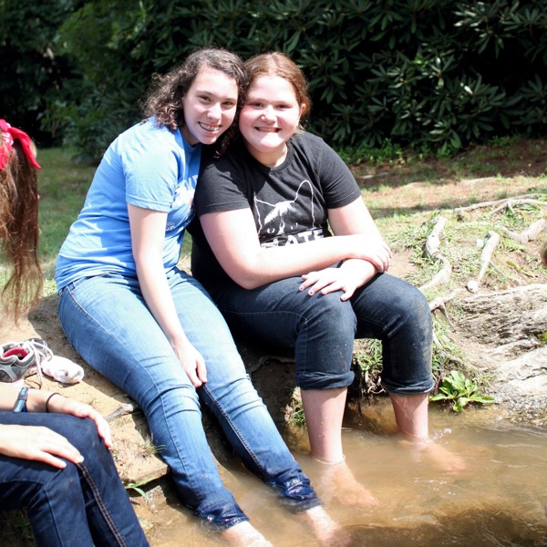 Girls with the feet in a stream