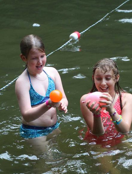 girls playing with balloons in the lake