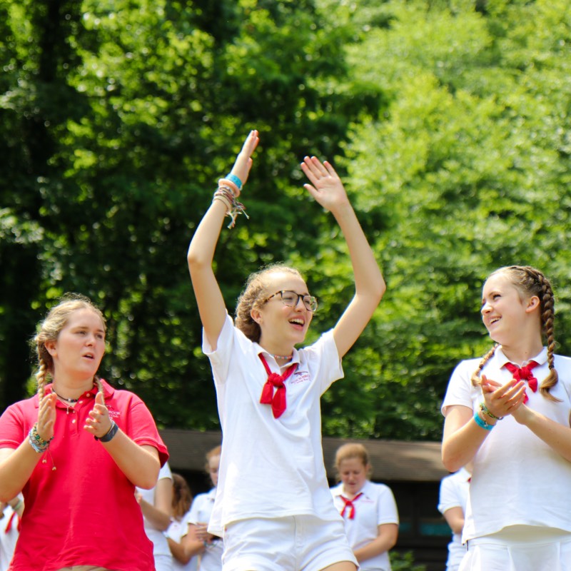 girls cheering at summer camp assemby
