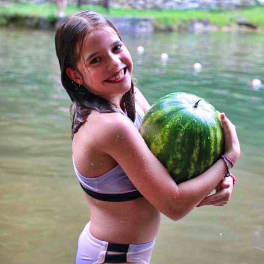girl holding watermelon near the lake