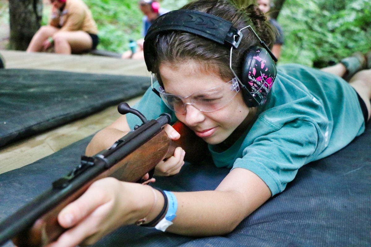 girls aiming rifle