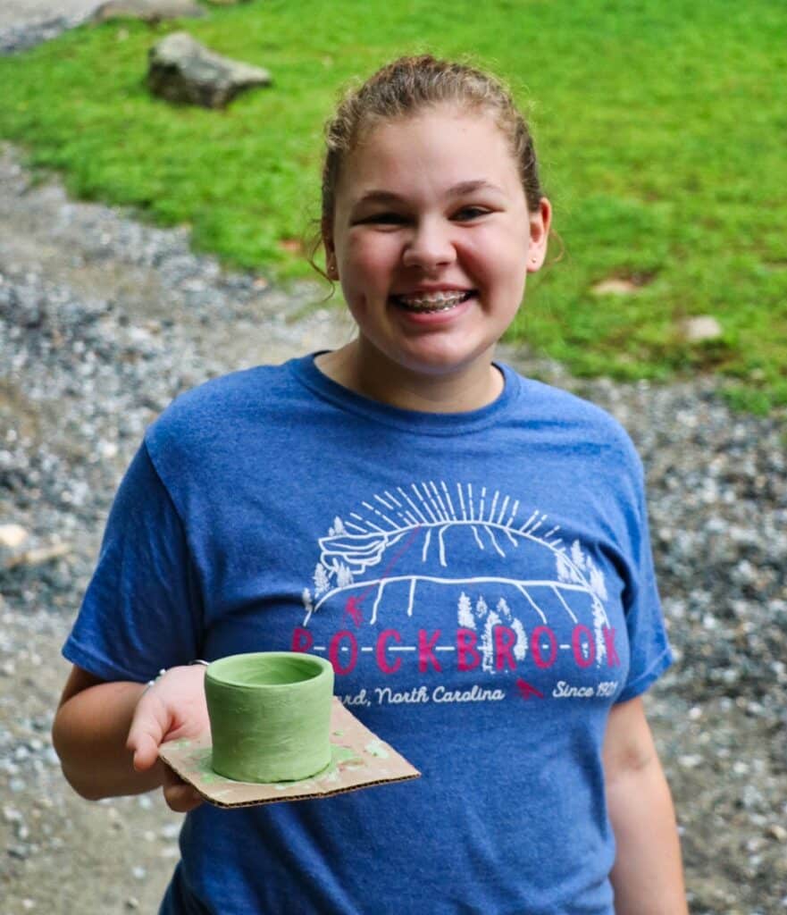 girl holding camp pottery glazed