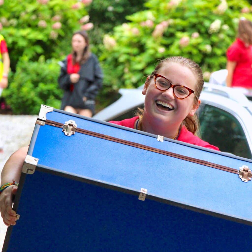 camp counselor carrying a trunk