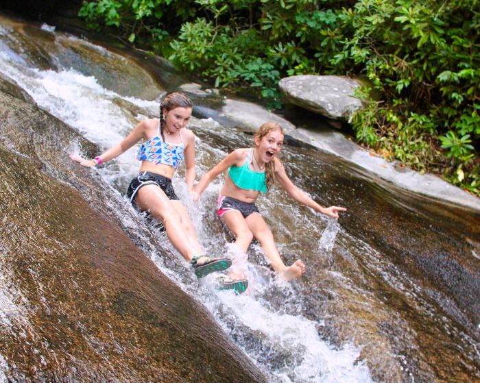 two teenage girl sliding down water