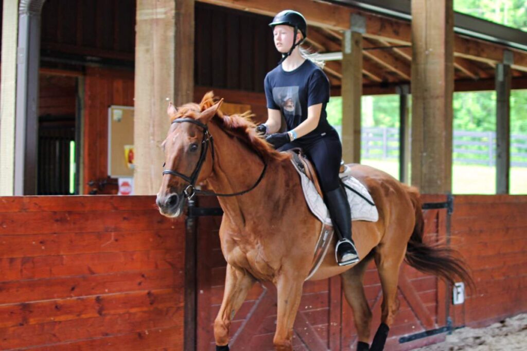 teen girl riding horse at summer camp