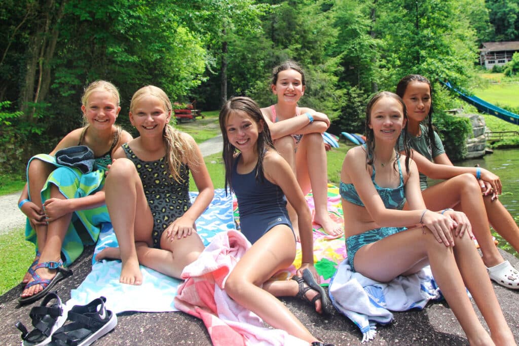 Summer camp teens sitting on a rock