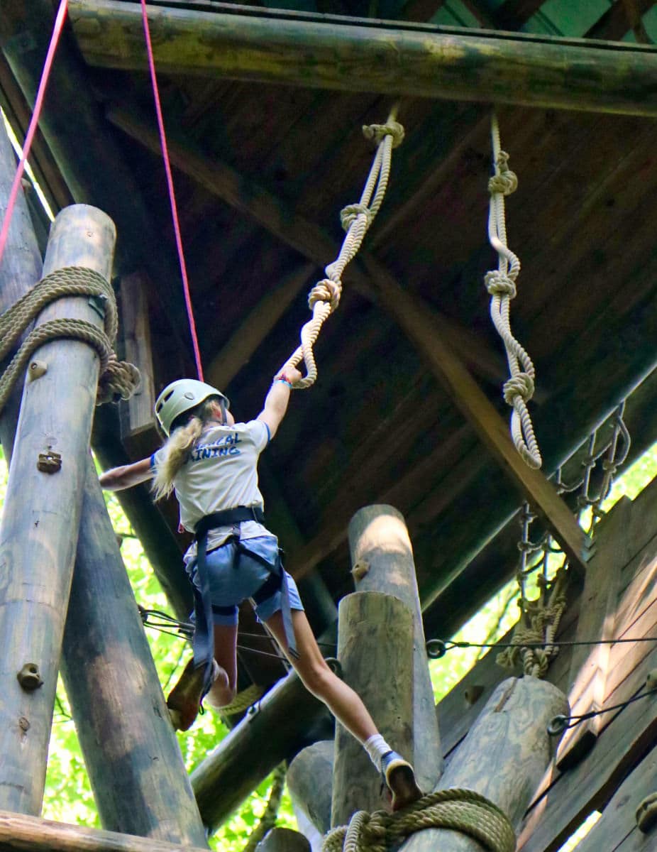camp girl climbing a tower